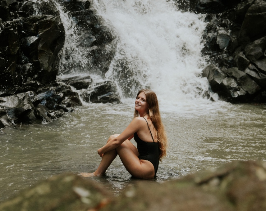 A view over a woman enjoying one of the many waterfalls of mauritius