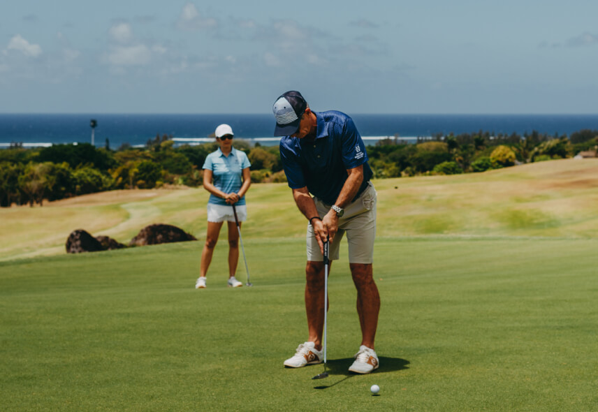 A couple playing golf together at Le Chateau Golf Course, showcasing a fun and active outdoor experience - Heritage Golf Club
