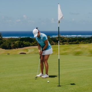 Golfer playing a round at La Réserve Golf Links with coastal views