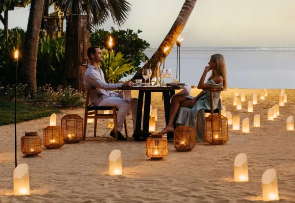Couple enjoying a beachfront candlelit dinner in the evening, Mauritius