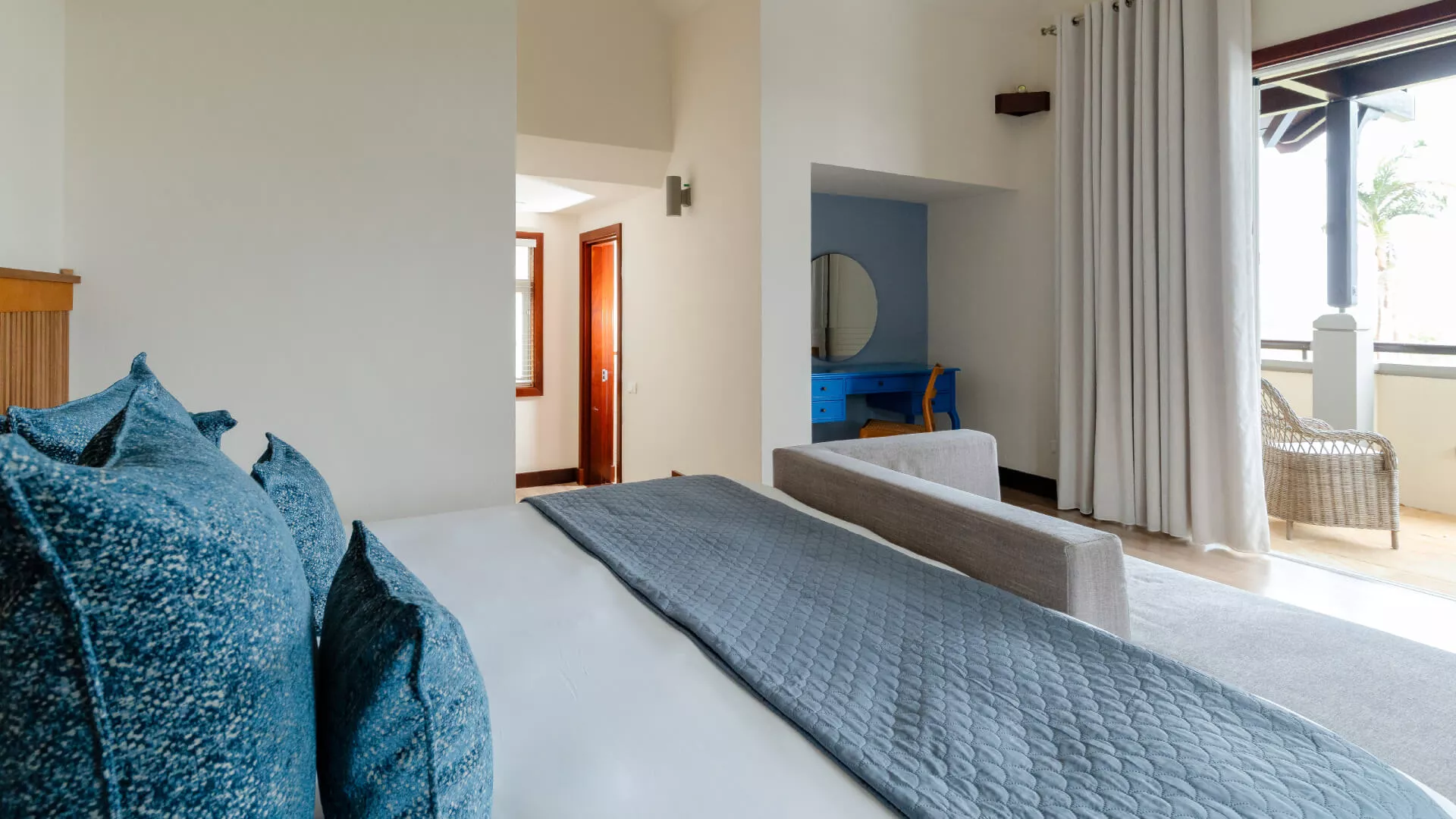 Side view of a top floor bedroom in a luxury four-bedroom villa featuring balcony access