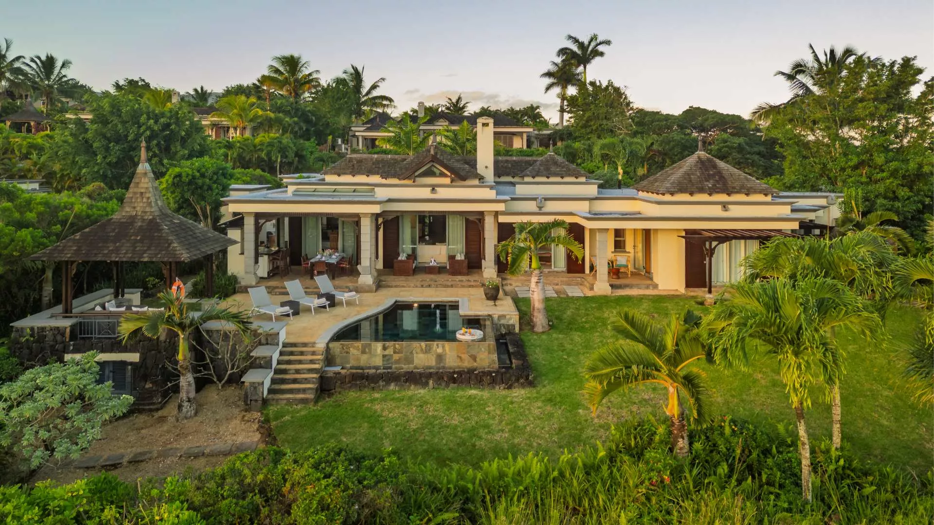 Exterior landscape view of a luxury three-bedroom villa surrounded by lush greenery