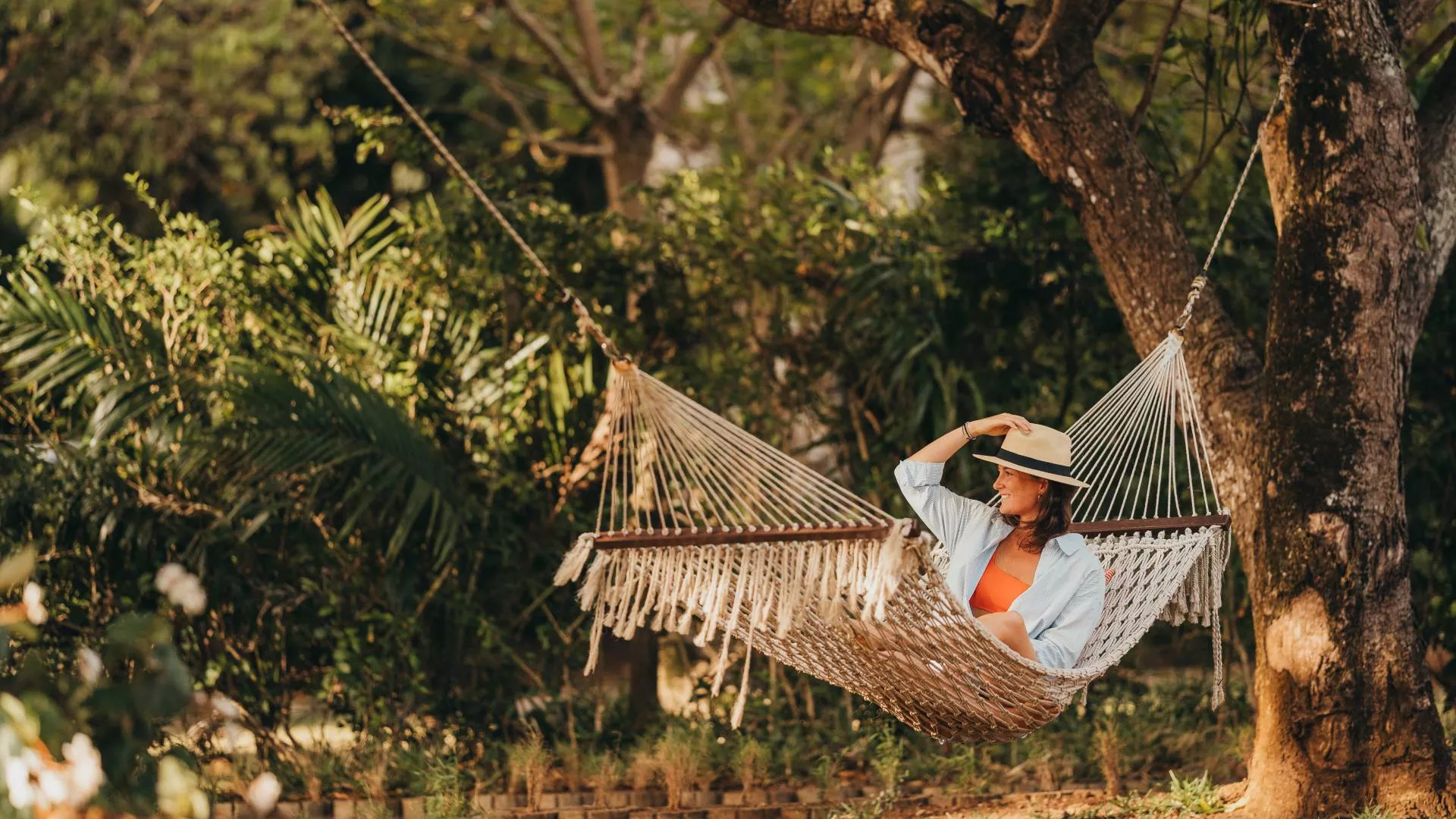 jeune femme dans un hamac sous les arbres tropicaux à maurice