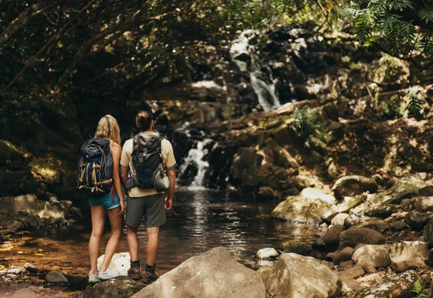 Couple hiking near a scenic waterfall in Mauritius