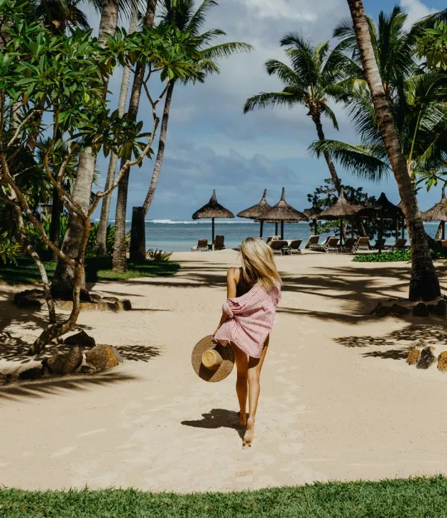 Woman walking along the beach on a sunny day with clear skies