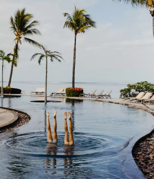 Kids in a playful upside-down pose during a lively pool moment