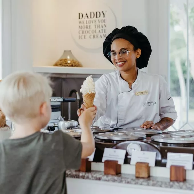 child being served ice cream by heritage le telfair staff mauritius