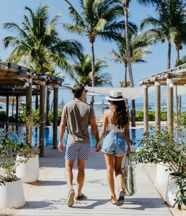 paar geht hand in hand am pool vor dem strand c beach club