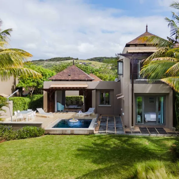 Exterior view of a luxury 4-bedroom villa surrounded by lush greenery