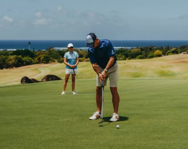 Golfer couple at early tee time on La Réserve Golf Links in Mauritius
