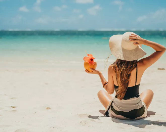 woman sitting on long white sand beaches mauritius august holidays